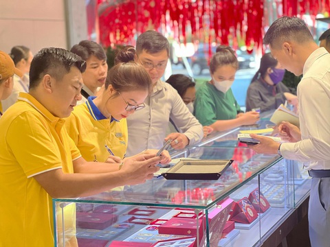 Nhộn nhịp ngày Thần Tài: Đa dạng mẫu mã vàng và hình thức mua sắm- Ảnh 7. Tư vấn viên PNJ hỗ trợ khách mua hàng - Ảnh: VIỆT HÙNG