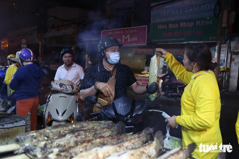Ngày vía Thần Tài: Đổ xô mua cá lóc nướng, có gian hàng đã bán hơn 3.000 con- Ảnh 5. "Nhà gần đây nên tôi ghé mua trước để có thể lựa cá, mặc dù trưa nay nhà mới cúng. So với năm ngoái thì giá năm nay có tăng lên chút đỉnh, tôi chọn một con cá vừa với giá 200.000 đồng", anh Cường (ngụ quận Tân Phú) chia sẻ.