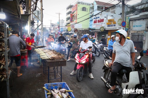 Ngày vía Thần Tài: Đổ xô mua cá lóc nướng, có gian hàng đã bán hơn 3.000 con- Ảnh 7. Gian hàng cá nướng Cúc Bụi từ ngày hôm trước đã phải tăng cường thêm người làm và các điểm bán để có thể đáp ứng nhu cầu của người mua