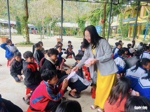 Học sinh vùng cao phấn khởi khoe lì xì buổi học đầu năm- Ảnh 5. Giáo viên Trường THCS Trà Tập phát bao lì xì năm mới cho các em học sinh - Ảnh: CLB