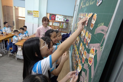 Gần 1,7 triệu học sinh TP.HCM trở lại trường sau kỳ nghỉ Tết dài- Ảnh 5. Các em tham gia các hoạt động vui nhộn trước khi vào tiết học mới, và vui nhất chính là "tiết mục" lì xì - Ảnh: NHƯ HÙNG