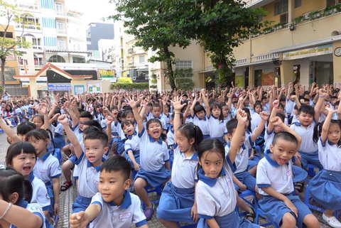 Gần 1,7 triệu học sinh TP.HCM trở lại trường sau kỳ nghỉ Tết dài- Ảnh 1. Học sinh Trường tiểu học Trần Hưng Đạo, quận 1, TP.HCM giơ tay thể hiện sự quyết tâm sẽ học thật tốt trong ngày đầu tiên đi học lại sau Tết - Ảnh: NHƯ HÙNG