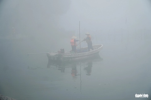 Chùm ảnh sương mù dày đặc, ở Hà Nội mà ngỡ Sa Pa, Đà Lạt- Ảnh 7. Hai công nhân vớt rác giữa hồ Tây - Ảnh: PHẠM TUẤN