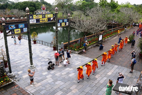 Hoàng cung Huế dựng nêu đón Tết Nguyên đán- Ảnh 3. Đoàn rước nêu đi ngang khu vực Ngọ Môn trong sự thích thú của du khách tham quan - Ảnh: NHẬT LINH
