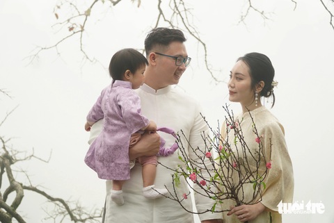 Chờ 4 tiếng săn ảnh tháp Rùa trong sương mù chưa từng có tại Hà Nội- Ảnh 1. Gia đình chị Dương Thu check-in hồ Gươm trong sương mù - Ảnh: NGUYỄN HIỀN