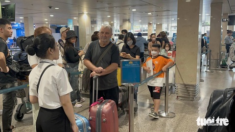 Cùng giờ mà chuyến đi sớm, chuyến delay từ sáng tới đêm, khách bay bức xúc 'đừng đổ lỗi cho trời'- Ảnh 4. Khách trật tự xếp hàng vào khu vực check-in của hãng Vietnam Airlines - Ảnh: CÔNG TRUNG