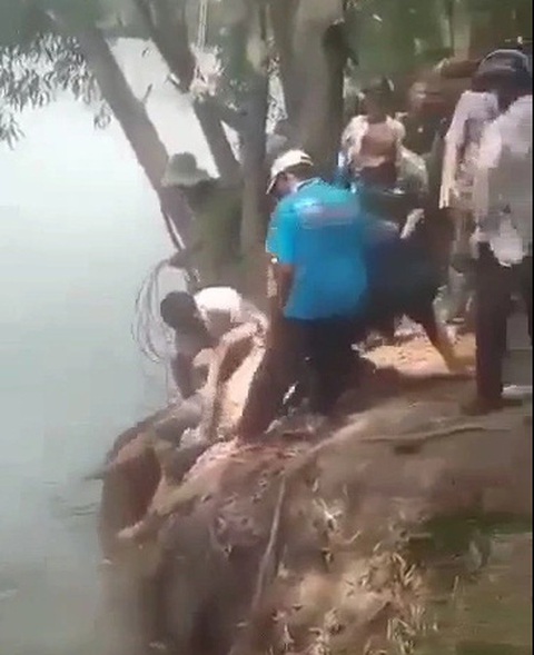 2 học sinh lớp 8 chết đuối dưới hồ nước hầm khai thác đất- Ảnh 1. Người dân tham gia tìm kiếm thi thể hai học sinh lớp 8 bị chết đuối - Ảnh trích xuất từ clip
