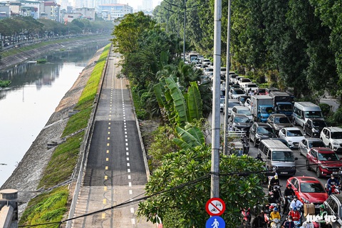 Ùn tắc cả ngày, người Hà Nội chật vật đi lại dịp giáp Tết- Ảnh 4. Trái ngược với cảnh ùn tắc cả ngày của đường Láng, làn đường dành cho xe đạp mới khai trương nằm sát đó lại không một bóng người sử dụng - Ảnh: HỒNG QUANG
