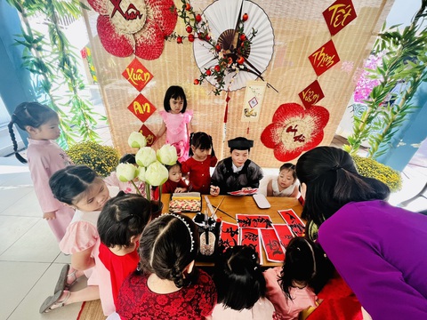 Đưa nội dung về Tết cổ truyền vào dạy trong trường phổ thông- Ảnh 3. Trẻ mầm non của Trường mầm non Thành Phố (quận 3, TP.HCM) thích thú với khu vực viết chữ thư pháp tại Lễ hội Xuân Giáp Thìn 2024 ở trường - Ảnh: MỸ DUNG