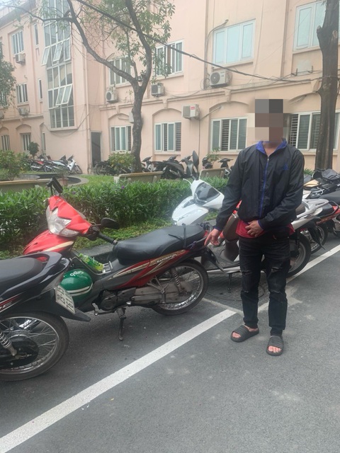 Tài xế nằm trên yên xe máy, tạt đầu ô tô ở đại lộ Thăng Long đã khai gì?- Ảnh 2. Tài xế và chiếc xe tại trụ sở công an - Ảnh: Công an cung cấp