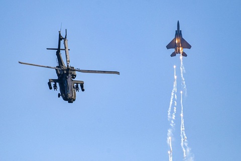 Mãn nhãn với triển lãm hàng không lớn nhất châu Á ở Singapore- Ảnh 8. Trực thăng Apache và tiêm kích F15SG của không quân Singapore trình diễn ngay trước Triển lãm hàng không Singapore hôm 18-2 - Ảnh: AFP