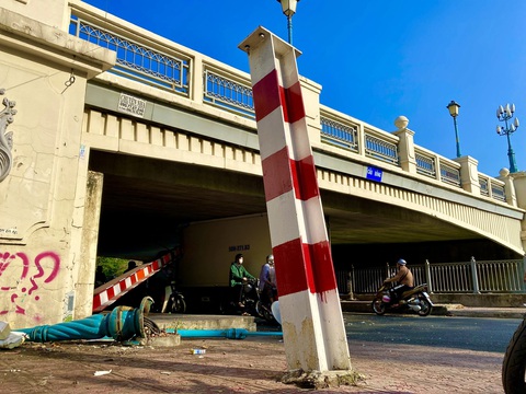 Xe tải tông sập khung giới hạn chiều cao, nằm kẹt dưới gầm cầu Bông- Ảnh 3. Cú va chạm khiến khung giới hạn trước cầu Bông bị hư hỏng hoàn toàn, thanh chắn ngang bị móp cong nặng, một trụ đứng bị gãy - Ảnh: TIẾN QUỐC