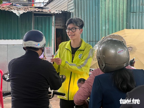 Đi lễ phủ Tây Hồ thu phí gửi xe không dừng như ở trạm BOT- Ảnh 4. Ngoài khu vực gửi xe ô tô, tại bãi gửi xe máy ở phủ Tây Hồ cũng thu phí gửi xe không dùng tiền mặt bằng cách quét mã QR ngân hàng để thanh toán - Ảnh: PHẠM TUẤN
