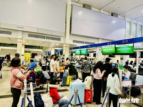 Vì sao Bamboo Airways loại dòng máy bay Embraer E190?- Ảnh 2. Hành khách làm thủ tục check-in ở Tân Sơn Nhất dịp Tết 2024 - Ảnh: CÔNG TRUNG