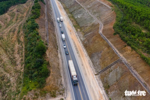 Xe container 'bò' trên cao tốc Cam Lộ - La Sơn nhưng vẫn chưa thể xử phạt- Ảnh 2. Một đoàn xe bám sát đuôi một chiếc xe đầu kéo chạy tốc độ chậm - Ảnh: HOÀNG TÁO