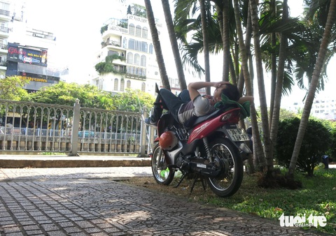 Một người đi xe máy ngủ trưa dười hàng cây bên bờ kênh trên đường Hoàng Sa, quận Phú Nhuận Một người đi xe máy ngủ trưa dưới hàng cây bên bờ kênh trên đường Hoàng Sa, quận Phú Nhuận.