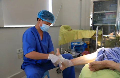 Chỉ trẹo chân, người phụ nữ mắc tiểu đường phải cắt cụt cả hai chân vì tự điều trị- Ảnh 1. Bác sĩ chăm sóc cho bệnh nhân biến chứng do mắc bệnh tiểu đường - Ảnh minh họa