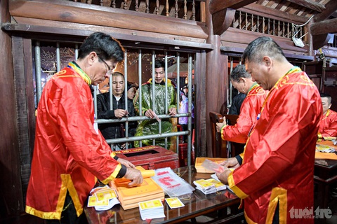 Bất ngờ đền Trần năm nay, phát ấn mới 15 phút đã vắng người- Ảnh 6. Chuẩn bị ấn để phát cho người dân và khách thập phương - Ảnh: NAM TRẦN