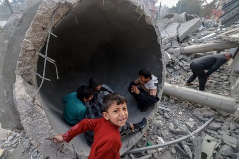 Sẽ có lệnh ngừng bắn ở Dải Gaza cho tháng Ramadan?- Ảnh 1. Trẻ em Palestine chơi đùa dưới hiện trường đổ nát của một nhà thờ Hồi giáo tại thành phố Rafah ở phía nam Gaza ngày 25-2 - Ảnh: AFP