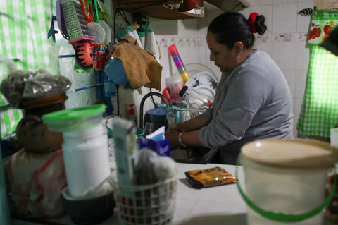 Một trong những thành phố lớn nhất thế giới sắp cạn kiệt nguồn nước- Ảnh 3. Một người phụ nữ rửa chén sau khi nhận được nước miễn phí vào ngày 31-1-2024 - Ảnh: REUTERS