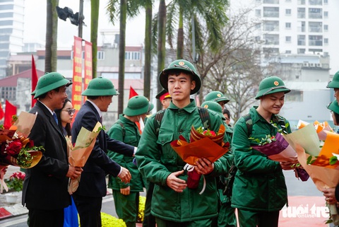 Đội mưa tiễn tân binh lên đường nhập ngũ- Ảnh 5. Các tân binh được tặng hoa và bước qua cổng vinh quang trước khi lên xe đến đơn vị
