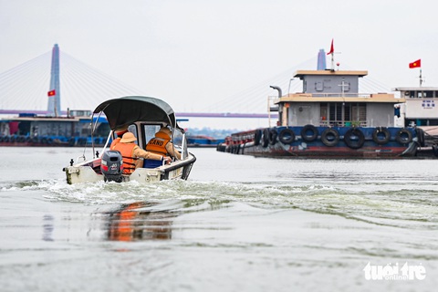 Cảnh sát giao thông đo nồng độ cồn người lái tàu trên tuyến sông Hồng- Ảnh 1. Cảnh sát tiếp cận một tàu chở hàng trên sông Hồng - Ảnh: HỒNG QUANG