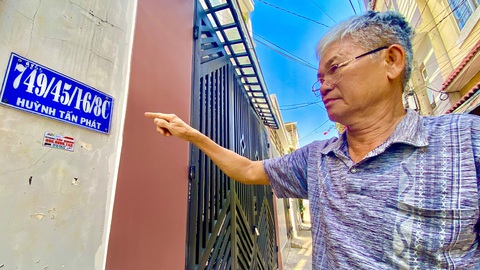 Số nhà ở TP.HCM vẫn loạn xạ sau 25 năm chấn chỉnh- Ảnh 1. Ông Lê Tấn Lâm chỉ tay biển số nhà có 4 xuyệt tại Huỳnh Tấn Phát (quận 7, TP.HCM) - Ảnh: TIẾN QUỐC