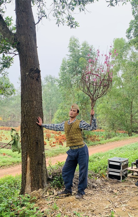 'Đào, phở và piano' nhận lời chê vô lý, nam chính Doãn Quốc Đam phản pháo- Ảnh 1. Nam chính 'Đào, phở và piano' Doãn Quốc Đam và tư thế tạo dáng với cành đào gây sốt mạng xã hội