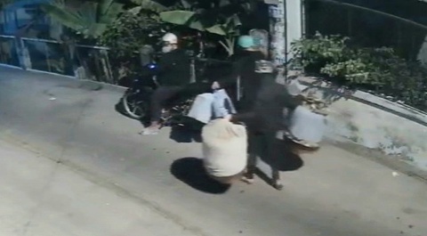 Xử lý 2 thanh niên trong nhóm trộm 7 lồng chim cảnh ở Hóc Môn- Ảnh 1. Hai nam thanh niên mang số lồng chim lên xe máy do một thanh niên khác đang chờ sẵn, rồi cùng rời đi - Ảnh cắt từ clip do người dân cung cấp