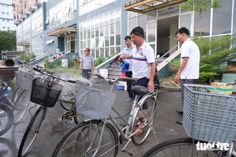 Cán bộ ký túc xá sửa xe đạp gửi tặng trẻ em khó khăn- Ảnh 1. Cán bộ nhân viên Trung tâm quản lý ký túc xá Đại học Quốc gia TP.HCM rửa lại những chiếc xe đạp cũ để gửi trao đến trẻ em khó khăn - Ảnh: NGỌC PHƯỢNG
