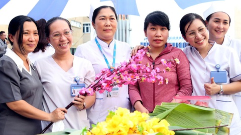 Nụ cười của thầy thuốc là niềm hy vọng cho người bệnh- Ảnh 1. Nụ cười của nhân viên y tế luôn mang lại niềm vui cho bệnh nhân. Trong ảnh: bác sĩ và thân nhân người bệnh cùng tham gia gói bánh mừng Tết Giáp Thìn tại TP.HCM - Ảnh: PHƯƠNG QUYÊN