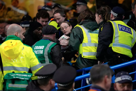 Cổ động viên Leeds rớt khán đài Stamford Bridge của Chelsea- Ảnh 3. Nhân viên sân Stamford Bridge cố gắng tiếp cận cổ động viên gặp nạn của Leeds - Ảnh: AP