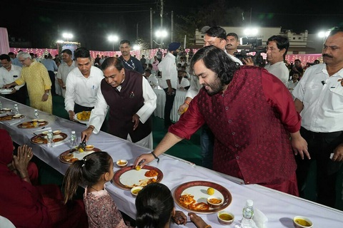 Mukesh Ambani (C), chairman at Reliance Industries with his son Anant Ambani (4R) attending to guests during Anna Seva (community food service) to seek blessings from various community members for the pre-wedding celebration of Anant Ambani and Radhika Merchant in Jamnagar. Photo: AFP Con trai tỉ phú Mukesh Ambani (áo đỏ) tiếp khách trong bữa tiệc mừng ở Jamnagar - Ảnh: AFP