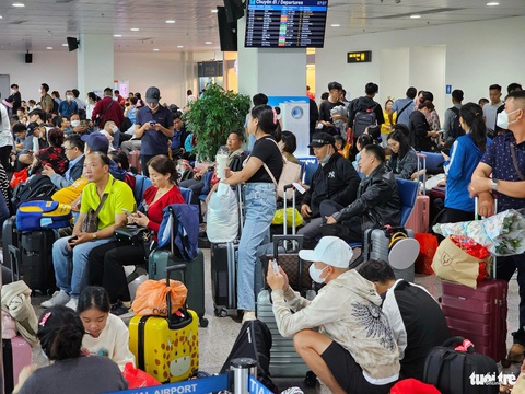 Ra sân bay Tân Sơn Nhất từ nửa đêm, tới sáng vẫn còn vật vờ chưa biết khi nào bay- Ảnh 1. Rất đông hành khách từ TP.HCM đi Vinh, Buôn Ma Thuột, Huế… ngồi chờ la liệt vì bị delay - Ảnh: THU DUNG