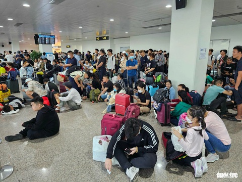 Ra sân bay Tân Sơn Nhất từ nửa đêm, tới sáng vẫn còn vật vờ chưa biết khi nào bay- Ảnh 3. Nhà chờ sân bay Tân Sơn Nhất sáng 3-2 la liệt khách chờ như đi tàu chợ - Ảnh: THU DUNG