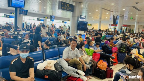 Thứ trưởng Bộ GTVT: Để xảy ra chậm chuyến, sân bay và hãng bay 'tiếc gì lời xin lỗi khách'- Ảnh 2. Hành khách ngồi chờ chuyến bay đông nghẹt người tại sảnh ra máy bay. Nguyên nhân nhiều chuyến bị hoãn (delay) từ 1-5 tiếng khiến nhà ga nội địa ùn ứ - Ảnh: CÔNG TRUNG