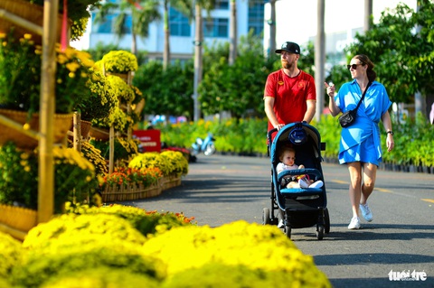 Đường hoa Phú Mỹ Hưng, TP.HCM khai mạc, hàng trăm du khách đã 'lên đồ' đi dạo- Ảnh 5. Nhiều du khách nước ngoài thích thú ngắm các tiểu cảnh đường hoa dọc hồ Bán Nguyệt