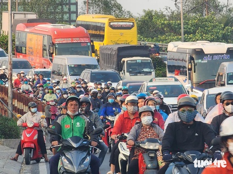Cửa ngõ phía tây TP.HCM ùn ùn dòng người đổ về quê ăn Tết- Ảnh 4. Đông nghịt xe cộ di chuyển chậm qua cầu Bình Điền (huyện Bình Chánh) vào khoảng 17h20 ngày 3-2 - Ảnh: NGỌC KHẢI