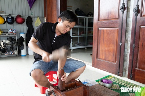 Âm thanh của làng bánh hộc ngày Tết gợi nhớ bao mùa xuân qua- Ảnh 1. Nguyên liệu được đổ vào khuôn gỗ rồi dùng chày giã mạnh nén thành bánh - Ảnh: HOÀNG TÁO