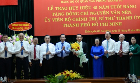Chủ tịch nước trao huy hiệu 45 năm tuổi Đảng cho Bí thư Thành ủy Nguyễn Văn Nên- Ảnh 2. Ban Thường vụ Thành ủy TP.HCM trao hoa chúc mừng Bí thư Thành ủy Nguyễn Văn Nên - Ảnh: TIẾN LONG