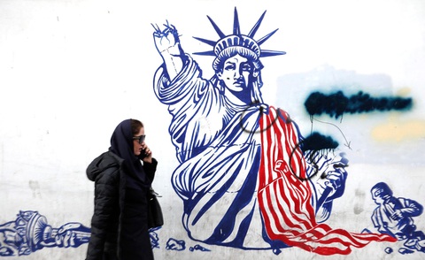 Mỹ sẽ đáp trả Iran ở mức độ nào?- Ảnh 1. Một người phụ nữ đi ngang qua tranh vẽ graffiti chống Mỹ bên ngoài tòa nhà trước đây là nơi đặt Đại sứquán Mỹ ở Tehran vào hôm 30-1 - Ảnh AFP