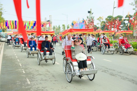 Nô nức check-in tại con đường hoa xuân lớn nhất phía tây thủ đô Home Hanoi Xuan 2024- Ảnh 10. Khám phá đường hoa bằng xích lô là sở thích của các đại biểu và du khách quốc tế khi đến với Home Hanoi Xuan trong nhiều năm qua - Ảnh: Quang Anh