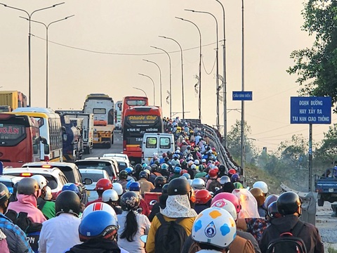 Cửa ngõ phía tây TP.HCM ùn ùn dòng người đổ về quê ăn Tết- Ảnh 3. Đông nghịt xe máy, ô tô nối đuôi nhau di chuyển chậm qua cầu Bình Điền (huyện Bình Chánh) vào khoảng 17h20 ngày 3-2 - Ảnh: NGỌC KHẢI
