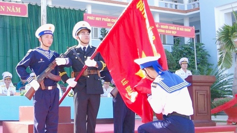 Vững chãi ngày xuất ngũ- Ảnh 1. Chiến sĩ tiêu biểu Nguyễn Đình Dũng đại diện các chiến sĩ hôn lá cờ Tổ quốc trước giờ ra quân - Ảnh: MAI THẮNG