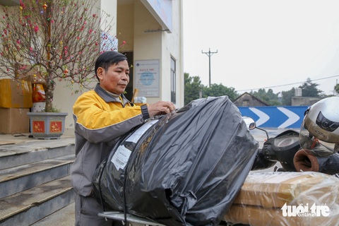 Ông Đoàn Văn Hùng cẩn thận kiểm tra từng đơn hàng và tính lộ trình trong đầu trước khi đi giao cho khách - Ảnh: HÀ QUÂN Ông Đoàn Văn Hùng cẩn thận kiểm tra từng đơn hàng và tính lộ trình trong đầu trước khi đi giao cho khách - Ảnh: HÀ QUÂN