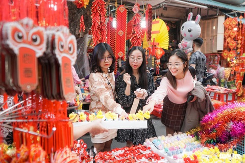 Người Hà Nội đi sắm Tết ngày nắng ấm, phố cổ, trung tâm thương mại kín người- Ảnh 3. Những bạn trẻ sắm những phụ kiện dễ thương đón Tết - Ảnh: PHẠM TUẤN