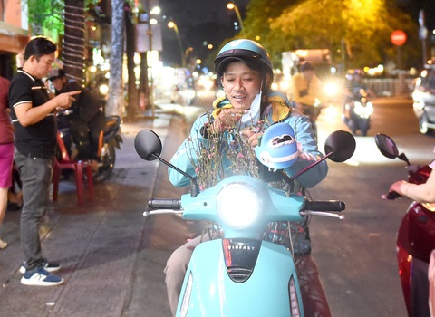 Tết gặp nhau không than nghèo kể khó, thăm hỏi chứ đừng 'tra hỏi'- Ảnh 1. Anh tài xế lái xe công nghệ vui vẻ ngắm nhìn cây đào vừa mua được trong lúc chờ khách tại một quán nhậu trên đường Hoàng Sa, quận 3, TP.HCM - Ảnh: TỰ TRUNG