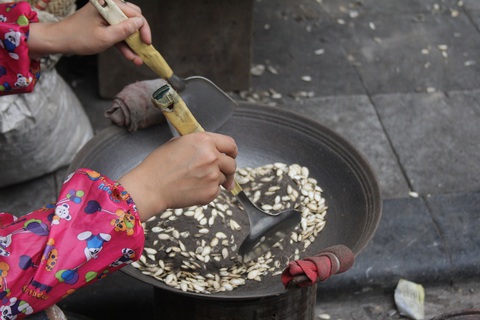 Thưởng thức Tết đậm vị như người dân Hà thành- Ảnh 10. Rang hạt bí để nhâm nhi trong ngày Tết