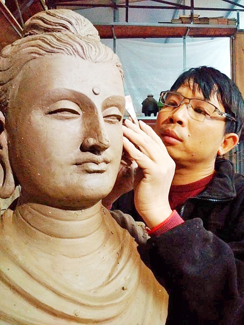 Nghệ sĩ Lương Thanh làm tượng Phật để mọi người hạnh phúc- Ảnh 2. Nghệ sĩ điêu khắc Lương Thanh bên bức tượng Phật tại xưởng điêu khắc của anh - Ảnh: T.ĐIỂU