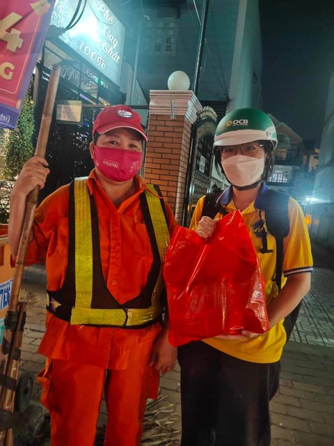 Sinh viên gói bánh chưng tặng chú bảo vệ, cô lao công- Ảnh 7. Phần bánh chưng được các bạn sinh viên trao đến cô công nhân vệ sinh đang làm việc trong đêm ở TP Thủ Đức - Ảnh: UFM